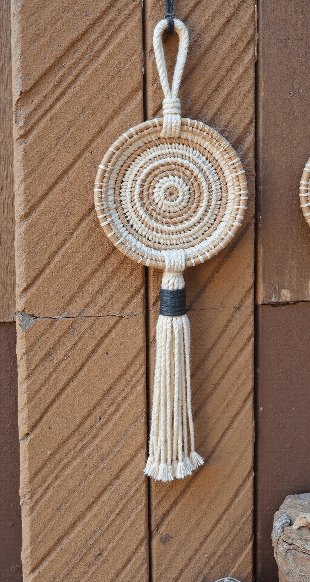Bohemian geïnspireerde hoek met textielbehang, handgemaakte wandplanken van gerecycled hout met vintage speelgoed en gedroogde bloemen, rotan hangwieg met macramé details, verlicht door warm gouden namiddaglicht.