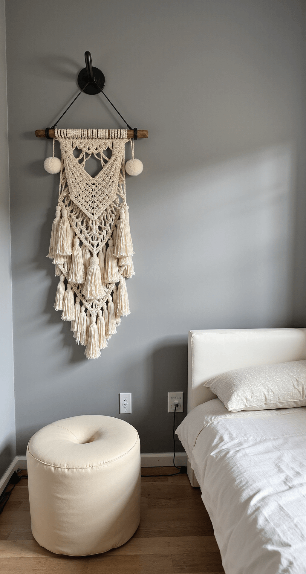 Intieme babykamer met grijze accentmuur, geometrische gele wandstickers, een gele kuipstoel, wit bijzettafeltje, macramé wandhanger, en industrieel zwart wandrek; sfeervol verlicht door natuurlijk licht.