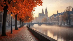 A panoramic view of Maastricht's historic city center in autumn, showcasing the Sint Servaasbasiliek, the Maas River, and warm fall colors with orange and red leaves. Early morning mist hovers over the river, historic streetlamps illuminate the cobblestone streets, and a bridge is visible in the background, highlighting the city's charming and atmospheric seasonal beauty.