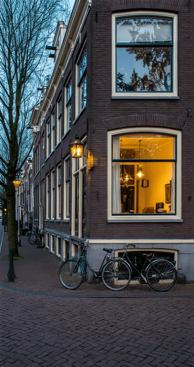 Jaren '30 oprit met klinkers in visgraatpatroon, klassieke gevelarchitectuur op achtergrond, dramatisch avondlicht, vintage fiets tegen schone muur, straatniveau camera met symmetrische compositie en leidende lijnen.