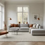 Moderne Scandinavische woonkamer met een warme, grijs L-vormige bank op een crèmekleurig handgeweven wollen tapijt, verlicht door natuurlijk daglicht dat door de vloer- tot plafondramen stroomt, met vintage koperen vloerlampen en terracotta accenten op eikenhouten herringbone vloeren, in een minimalistisch ontwerp voor mid-century moderne meubels.