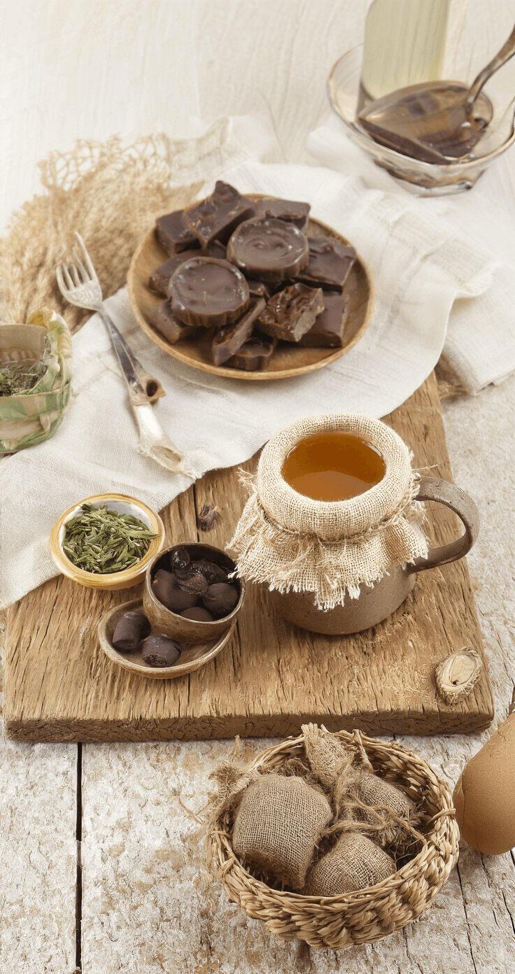 Kerstcadeaus van Natuurlijke Materialen: Duurzaam en Stijlvol Schenken Sfeervol eetgedeelte met biologische lekkernijen op een massief walnotenhouten tafel, handgemaakte keramische schalen met chocolade en jam, fairtrade koffie in hennep zakjes, verse biologische thee in rieten manden, vintage glasbokalen en een linnen tafelloper, verlicht in gouden uurtje-licht.
