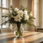 A beautifully arranged winter floral display featuring white amaryllis, eucalyptus, and pine branches in an elegant glass vase, set on a robust wooden dining table with warm oak flooring, surrounded by antique brass and vintage copper accents in a softly lit Dutch interior, capturing a moody atmosphere with natural sunlight and bokeh effects.