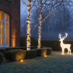 Cinematic exterior view of a Dutch winter garden at twilight, featuring LED string lights on a silver birch, illuminated brick facade, net lighting on boxwood shrubs, and a white reindeer on frost-covered grass, all under soft blue hour lighting with golden accents, creating a magical atmosphere enhanced by subtle fog and snow-dusted decorations.